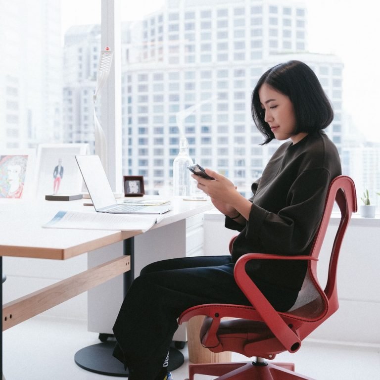 aplicativo de decoração - mulher sentada na cadeira mexendo no celular